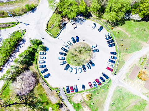 Aerial view of Nice round parking lot full of cars at the Maizerets Domain during springtime day