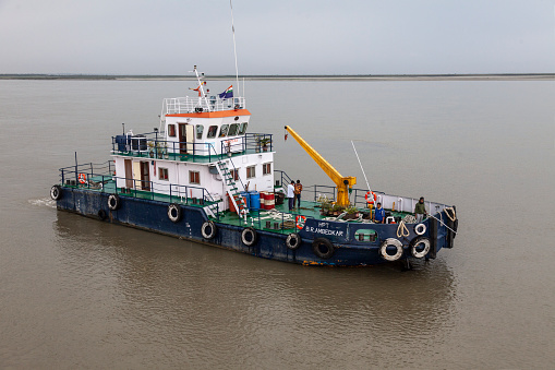 4th April 2023 - Brahmaputra River, india - Tugboat HPT B.R. Ambedkar preparing to help to pull a cruise ship off a sandbank on the Brahmaputra River in Assam, India, where the channels - and sandbanks - change constantly.