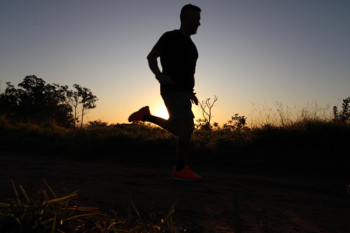 silhouette of a man running at sunset