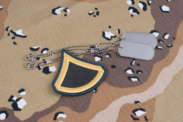 istock US ARMY Private First Class rank patch and dog tags on desert camouflage uniform 1491377365