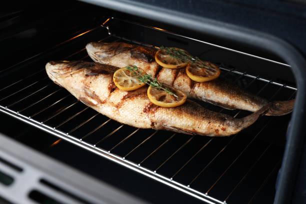 istock Rack with sea bass fish, lemon and thyme in oven 1491378116