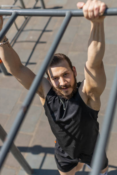 istock Athletic lebanese man in sportswear doing pull ups exercises on horizontal bar, pumping up back 1491389082
