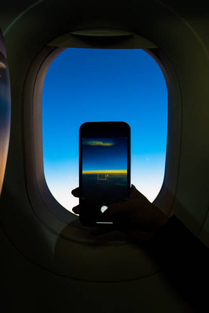 istock Sunrise from an airplane window while taking photos with a mobile phone. 1491389469