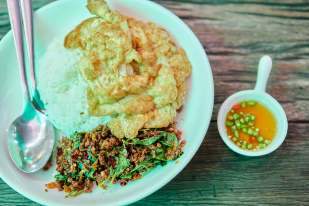 istock Thai stir-fried basil beef with rice and omelet in white plate 1491391454