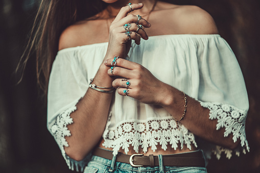 Beautiful fashionable boho chic woman in a white short blouse with silver turquoise jewelry, hippie style