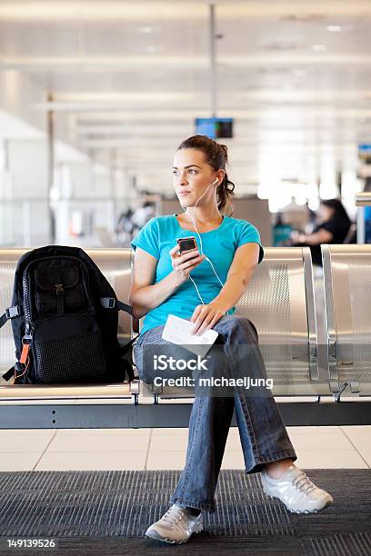 Foto de Jovem Mulher Esperando Por Seu Voo No Aeroporto e mais fotos de stock de Aeroporto - Aeroporto, Camiseta, Mulheres