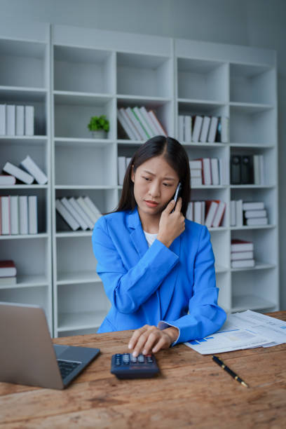 istock Busy businesswoman wearing a suit busy with work workaholic while sitting at work clear paperworks with documents and talk on the phone on your smartphone hear the hustle and bustle, busy concepts. 1491401114