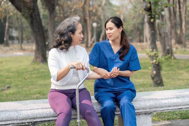 手をチェックし、高齢者の手をマッサージする女性看護師 病院公園の世話 - male nurse medical student healthcare and medicine nursing assistant ストックフォトと画像