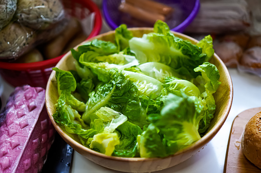 The picture shows a bowl of fresh lettuce for preparing a vegetarian dish.