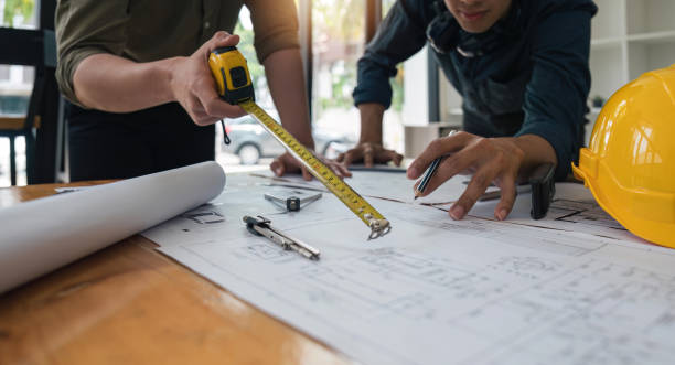 Construction concept of meeting engineers or architects for projects working with partners and engineering tools on modeling and blueprint design in office
