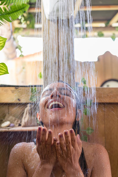istock Refreshing Bliss: Woman's Joyful Shower in Outdoor Bathroom 1491409213