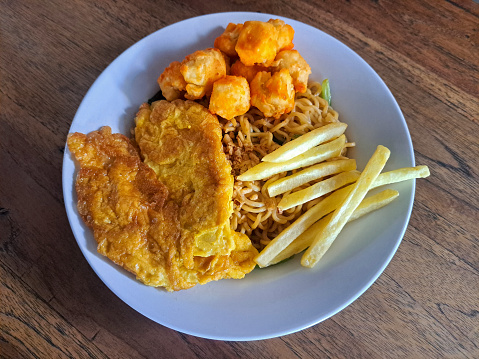 Fried Noodles With Fried Eggs, French Fries And Tofu Balado In Bowl