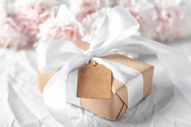 istock Gift box with brown tag with pink flower on crumpled texture 1491410539