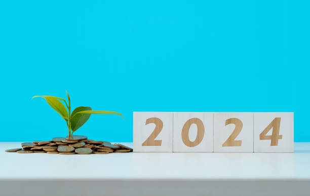 istock Heap of coins and number 2024 on white table 1491417132