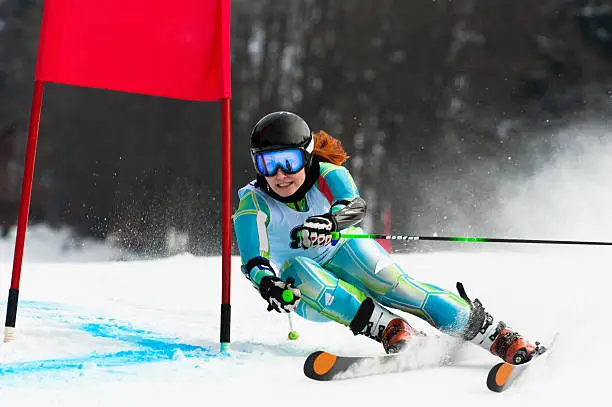 Front view of young female giat slalom competitor at red gate, real competition