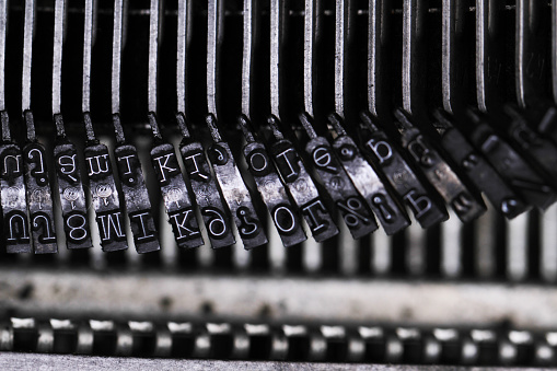 Old and dusty mechanical typewriter made in grey metal.