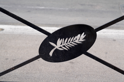 palm leaf emblem of the cannes film festival on a metal barrier