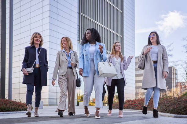 istock Businesswomen talking while walking together outdoors in financial district. 1491429521