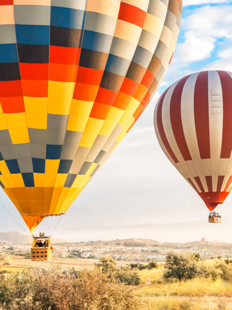 日の出、夜明けの早い山のカッパドキアで空に多くの明るい色の美しい風船を飛ばします。バーナーからの熱風でバルーンを満たし、大きなバスケット。観光ツアー、クラウドフライト - turkey hot air balloon cappadocia basket ストックフォトと画像