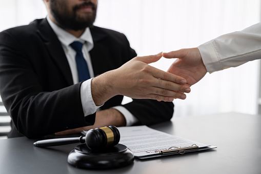 Closeup lawyer or attorneys colleagues handshake after successful legal discussing on contract agreement for lawsuit to advocate resolves dispute in court ensuring trustworthy partner. Equilibrium