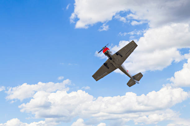 istock Aerobatic plane (aerodyne), in flight under a blue sky with white clouds. 1491434157