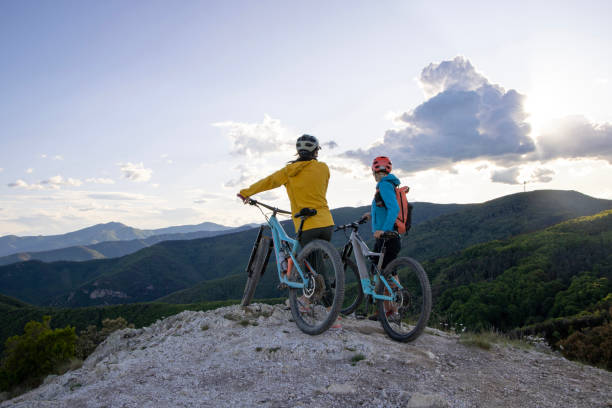 istock Young women pause on mountain top with bicycles 1491434226
