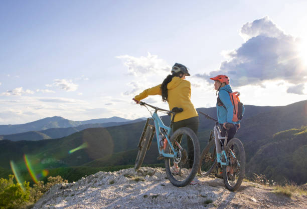 istock Young women pause on mountain top with bicycles 1491434275