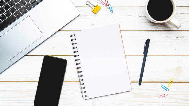 istock Creative mess on student's desk. Keyboard, notebook, smartphone,stationery, on wooden background. top view. copy space 1491435190