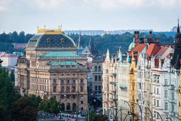 A night shot of the National Theatre Building in Prague: Trail light of a tram is in the foreground.