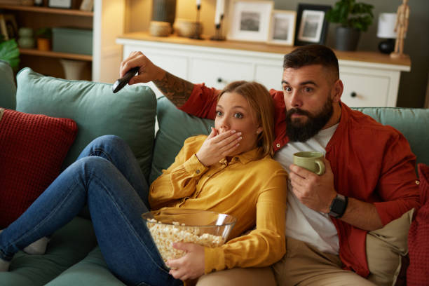 istock Couple watching scary movie on sofa at home 1491440091
