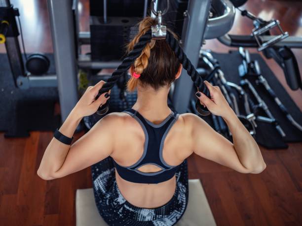 Young woman exercising in the gym using equipment