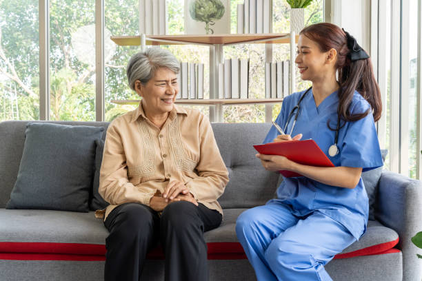 istock Young physical therapist female help aged female patient walk with walker 1491444312