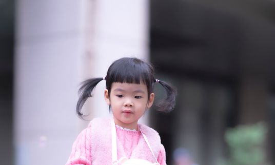 Cute little asian girl, kid portrait photo, play happily in the park