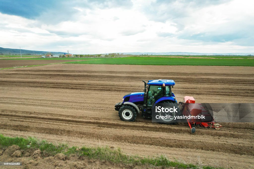 Drone top view of farmer planting corn in field with tractor and seeder with automatic regulation system 25-29 Years Stock Photo