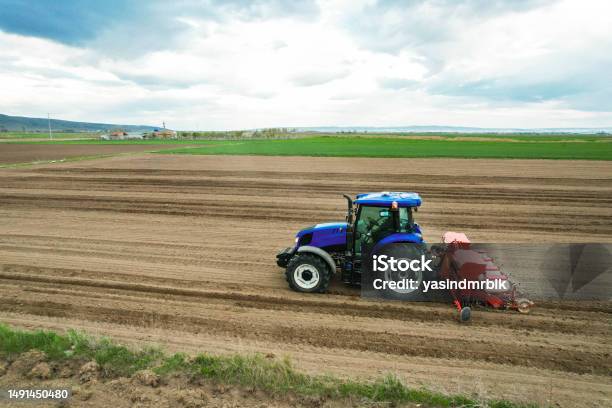 Drone Top View Of Farmer Planting Corn In Field With Tractor And Seeder With Automatic Regulation System Stock Photo - Download Image Now