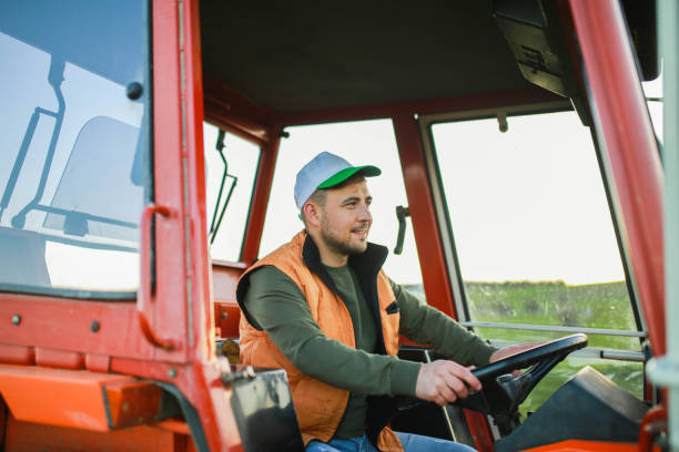 istock Young farmer man drives tractor in field 1491452218