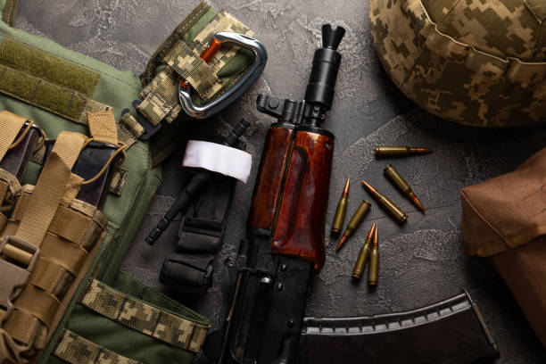 istock Military body armor, helmet and ammunition, a Kalashnikov assault rifle with matrons and a first aid tourniquet. On a black marble table. Army bulletproof vest. Flat lay. Military concept. 1491453355