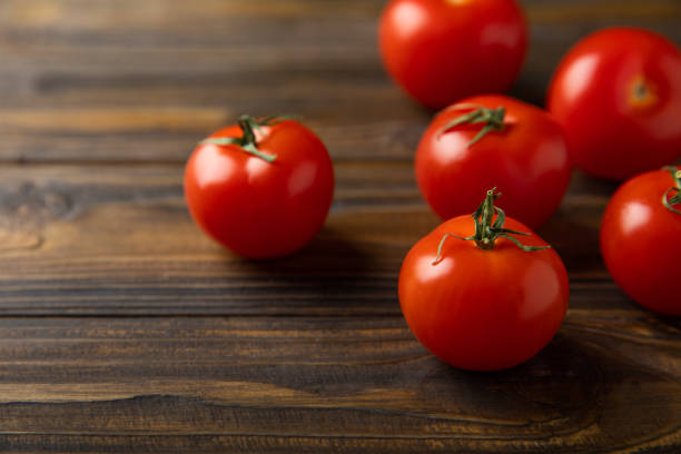 Fresh red tomatoes on brown texture background. Cherry tomatoes with green stems. fresh vegetables. Copy space.organic food