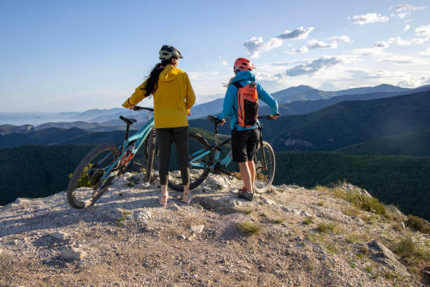 istock Young women pause on mountain top with bicycles 1491455492