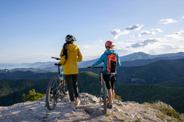 istock Young women pause on mountain top with bicycles 1491456311