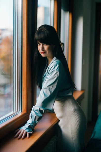 istock Beautiful young woman standing next to a window 1491457750
