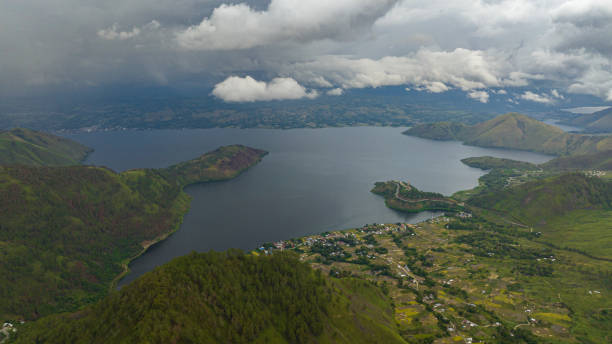 Aerial view of Toba lake and Samosir island. Sumatra, Indonesia. Top view of Lake Toba and Samosir island. among the mountains with tropical vegetation. Sumatra, Indonesia. lake toba indonesia stock pictures, royalty-free photos & images
