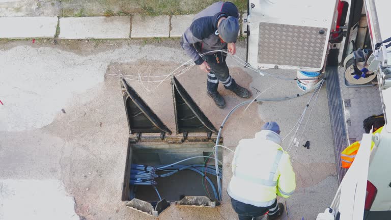 telecommunication technician proceeds with the cabling of fibre optic cables. In particular, individual fibre optic cables are pulled out of the protective sheathing