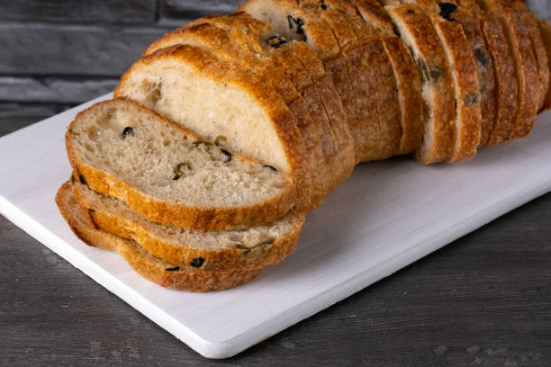 istock Bread with olives on a white cutting board on a gray table 1491459331