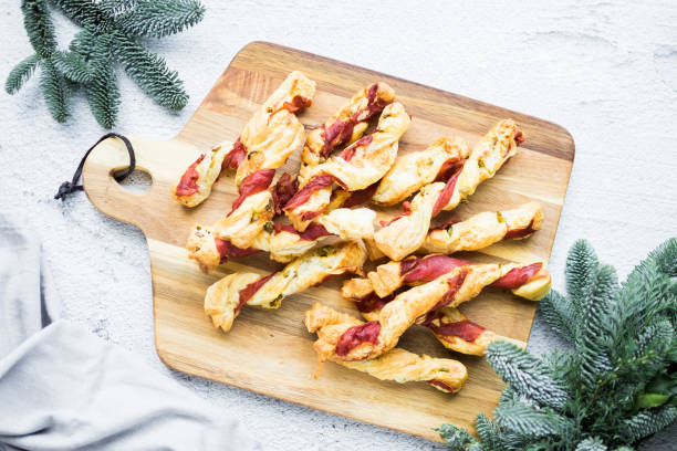 Puff pastry sticks. Close-up of puff pastry with prosciutto. Puff pastry sticks. Close-up of savory puff pastry swirls with prosciutto and olives. Recipe of appetizers idea. High quality photo. twisted bacon stock pictures, royalty-free photos & images