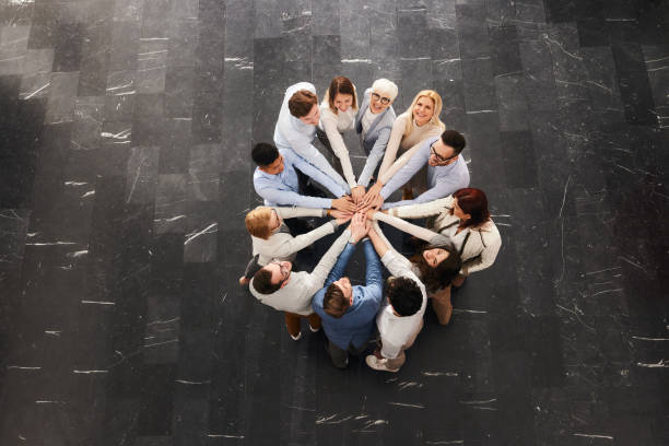 istock Above view of happy entrepreneurs uniting their hands. 1491461811