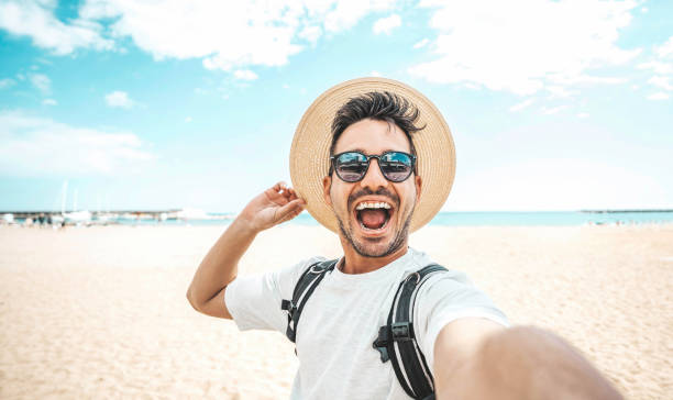 istock Handsome young man taking selfie picture at beach summer vacation - Smiling guy having fun walking outside - Summertime holidays and technology concept 1491461922