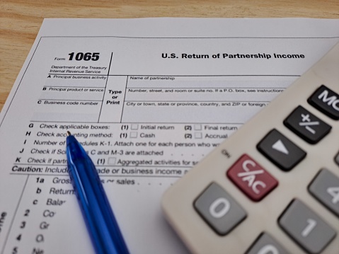 Tax 1065 American Income Form, U.S. Return Of Partnership Income. A Calculator And Pen.