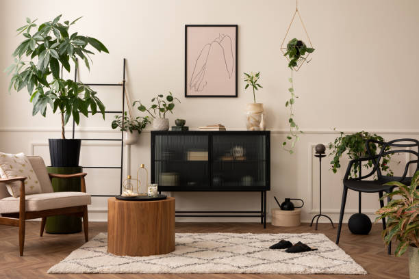 istock Creative composition of living room interior with mock up poster frame, black sideboard, round coffee table, stylish armchair, plants in flowerpots and personal accessories. Home decor. Template. 1491469080