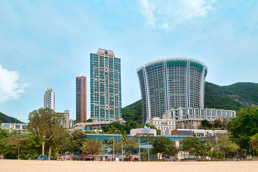 Hong Kong SAR, China - April 2023: High rise buildings skyscrapers and beach with golden sands at Repulse Bay